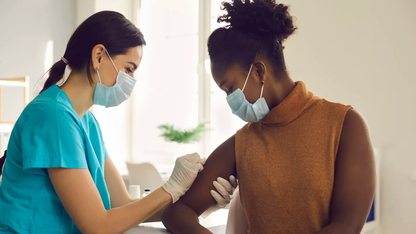 infirmière qui vaccine une patiente