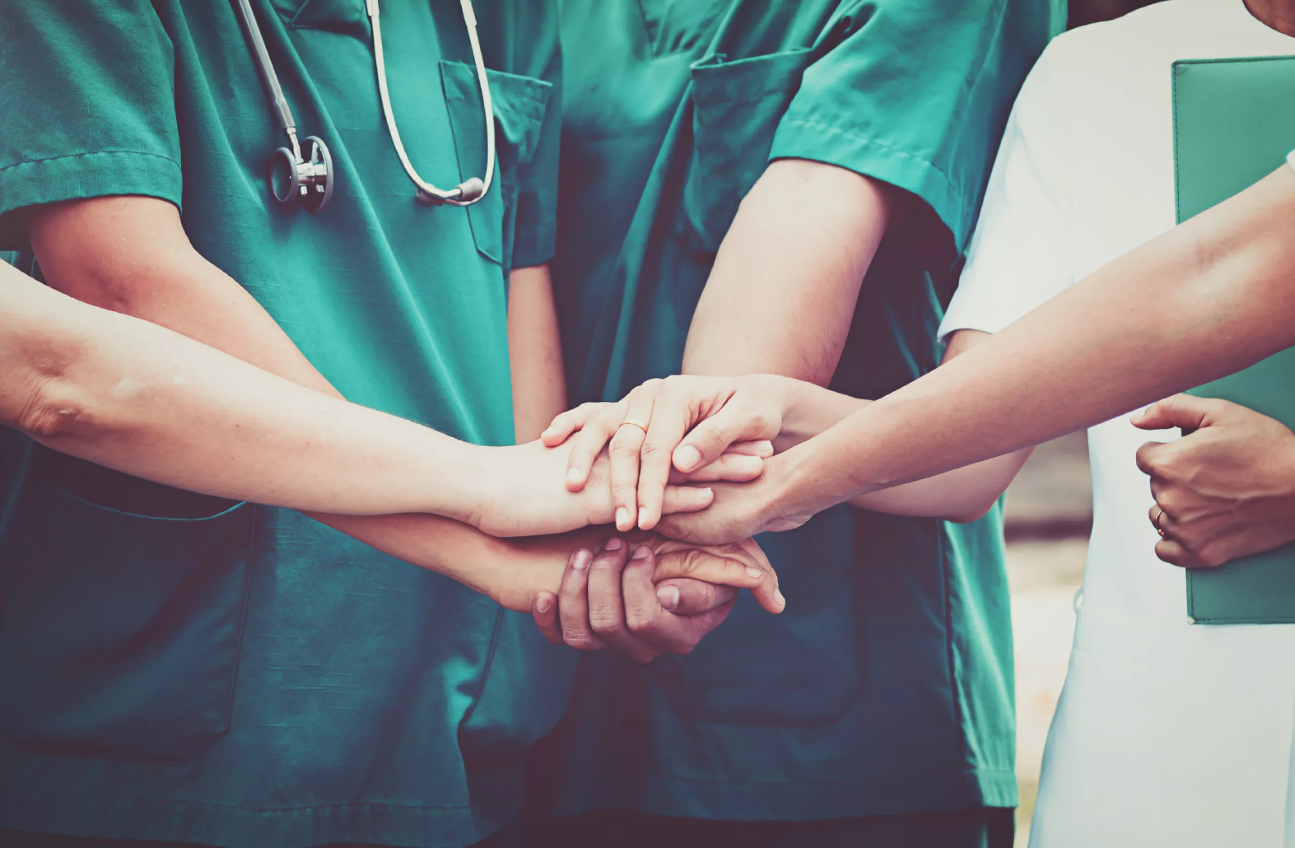 plusieurs mains d'infirmiers superposées